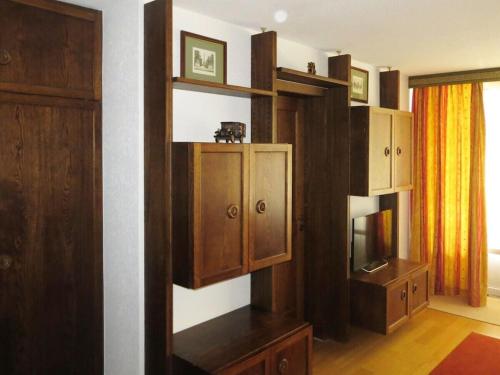 a living room with wooden cabinets and a television at Holiday apartment Constantin in Davos