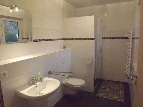 Holiday home in Schaprode with barbecue في Charlottendorf: حمام أبيض مع مرحاض ومغسلة