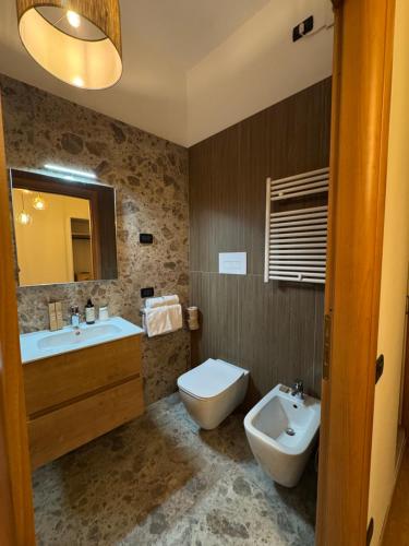 a bathroom with a sink and a toilet and a mirror at Centro Storico Suites Sarnico in Sarnico