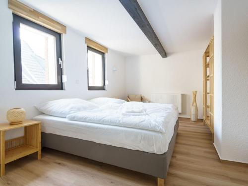 Holiday home Ahorn, 1st floor في Weilerswist: غرفة نوم بيضاء مع سرير ونافذة