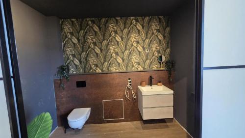 a bathroom with a toilet and a sink at Ferienhaus-Kleine-Austernperle in Dornumersiel