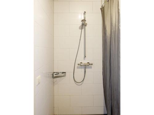 eine Dusche mit Duschvorhang im Bad in der Unterkunft De Rijtuigenschuur in Goudriaan