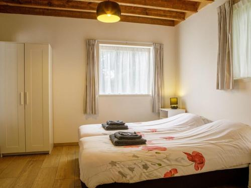 ein Schlafzimmer mit einem Bett mit Handtüchern darauf in der Unterkunft De Rijtuigenschuur in Goudriaan