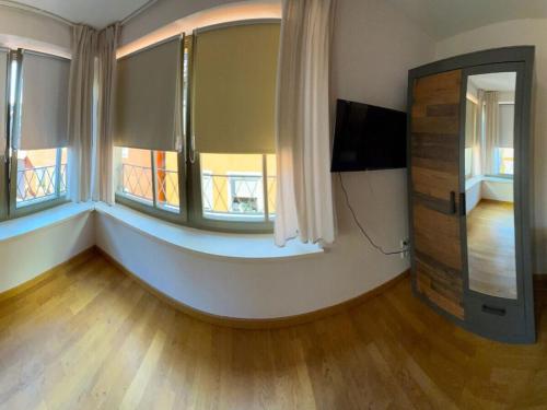 Una sala de estar con dos ventanas y un televisor de pantalla plana. en Holiday home Cityhouse WG 9, en Marktheidenfeld