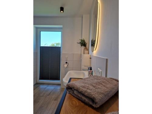 a living room with a table and a mirror at Holiday home Ebbe with dog up to 14 people in Schülp