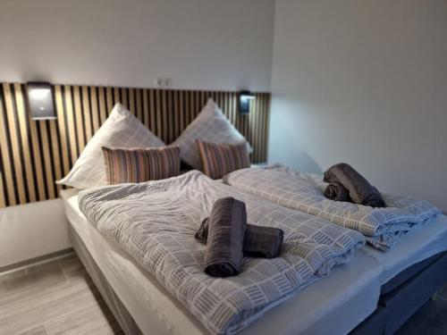 a large bed with two pillows on top of it at Holiday home Ebbe with dog up to 14 people in Schülp