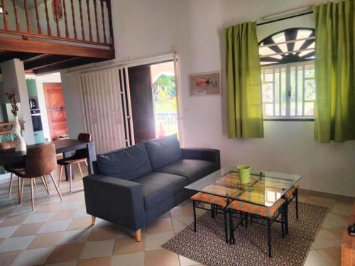 a living room with a couch and a table at La mélodieuse in Macouria