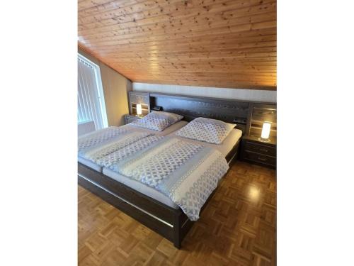 Holiday home Korn am Bärensteig في Bruchweiler-Bärenbach: سريرين في غرفة نوم ذات سقف خشبي