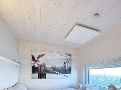 een slaapkamer met een foto aan de muur en een raam bij Houseboat STERN V in Heiligenhafen