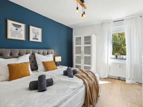 een slaapkamer met een groot bed met blauwe muren bij Hirschberg Living in Sankt Wendel