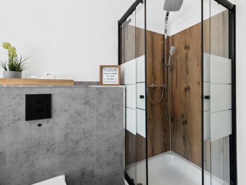 een douche met een glazen deur in een badkamer bij Hirschberg Living in Sankt Wendel