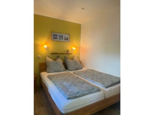 a bedroom with a bed with two pillows at Holiday home on Lake Kummerow in Salem