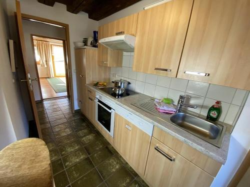 eine Küche mit Holzschränken und einer Spüle in der Unterkunft Hoher Göll in Punzenlehen in Engedey