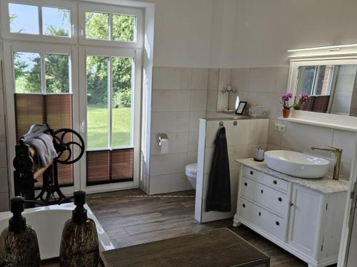 a bathroom with a tub and a sink and a toilet at Manor house apartment in Barlin