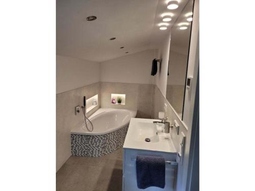 een badkamer met een ligbad en een wastafel bij Holiday home Littard in Rheurdt