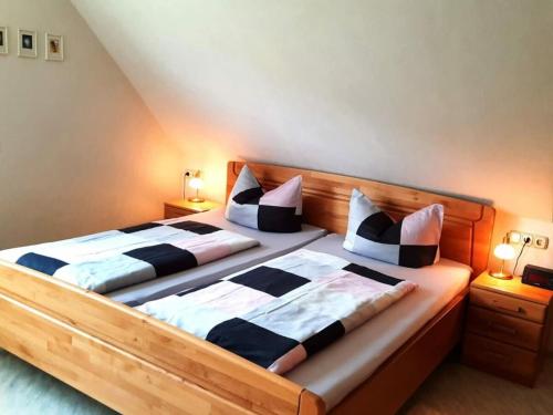 two beds in a bedroom with two lamps on the sides at 2 Weinhaus Marmann in Osann-Monzel