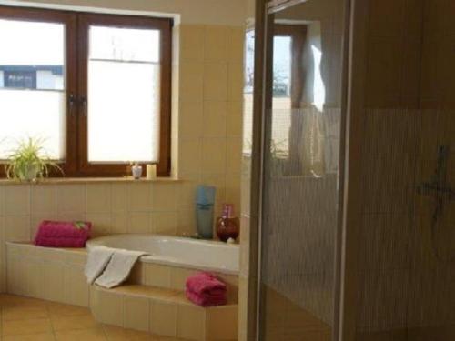 a bathroom with a bath tub and a window at Holiday apartment with 3 bedrooms in Holzendorf