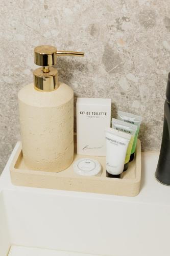 un vassoio di legno con una bottiglia di sapone e altri cosmetici di Studio Luma Dakar a Dakar