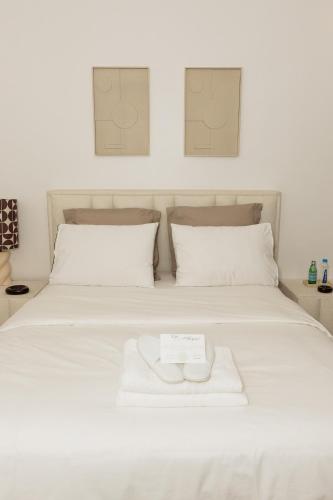 un letto bianco con un asciugamano bianco di Studio Luma Dakar a Dakar