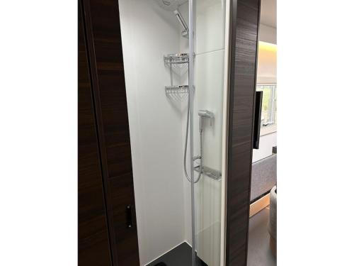 a bathroom with a glass shower stall with a door at Trailer in 03058 with swimming pool in Haasow