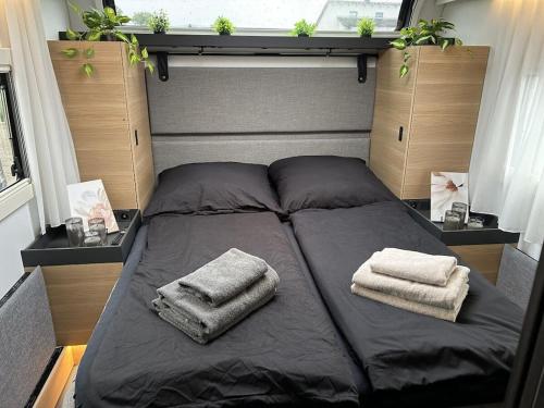 a bed in a room with two towels on it at Trailer in 03058 with swimming pool in Haasow