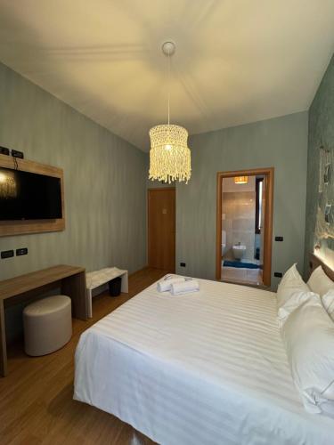 a bedroom with a large white bed and a chandelier at Centro Storico Suites Sarnico in Sarnico
