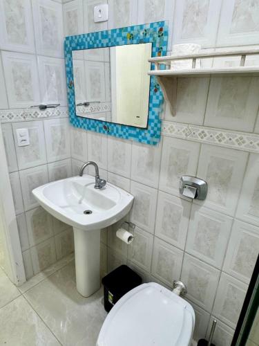 a bathroom with a sink and a toilet and a mirror at Casa Completa litoral SC com 4 qtos com ar condicionado e Aceita Pets in Itapema