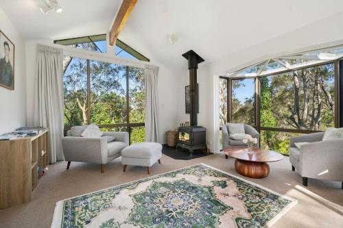 a living room with large windows and a fireplace at Alencon in Blackheath