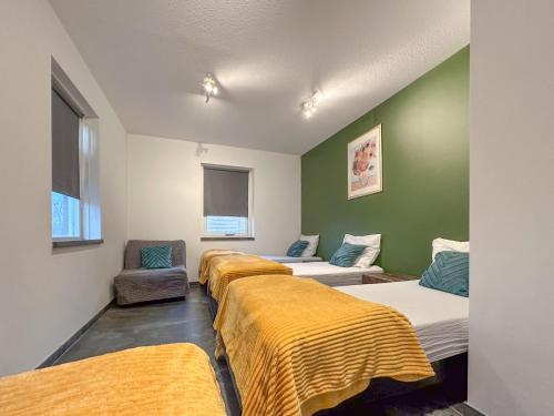 een rij bedden in een kamer met groene muren bij Landzicht in Haps