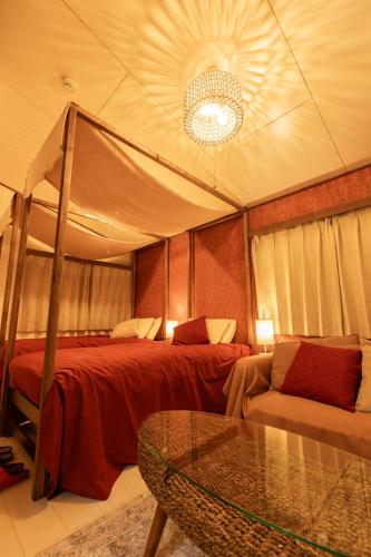 a bedroom with a canopy bed and a glass table at 那須Bitsは1棟貸で愛犬と過ごせる宿でBBQ無料プロジェクター完備 in Nasu