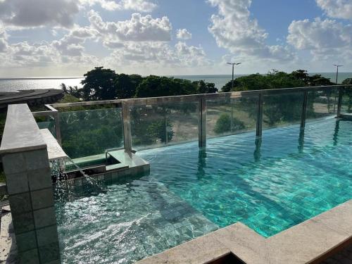a swimming pool with a view of the ocean at Israel Flat Tambau-Flat 409 COBERTURA in João Pessoa