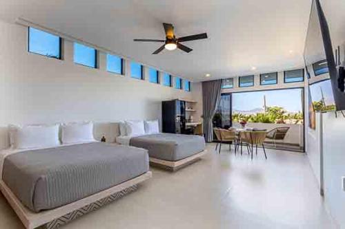 a bedroom with a large bed and a dining room at 605 Tower Downtown Cabo in Cabo San Lucas