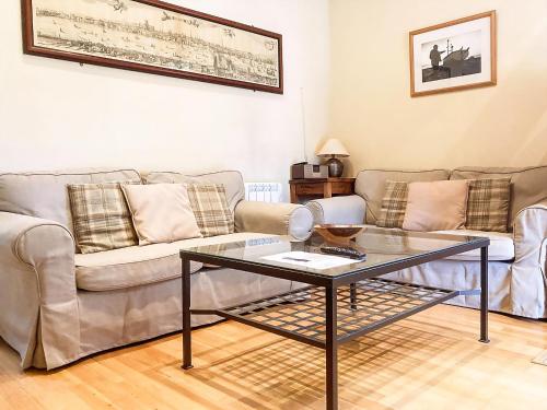 een woonkamer met een bank en een glazen tafel bij Valley Farm Cottage in Sudbourne