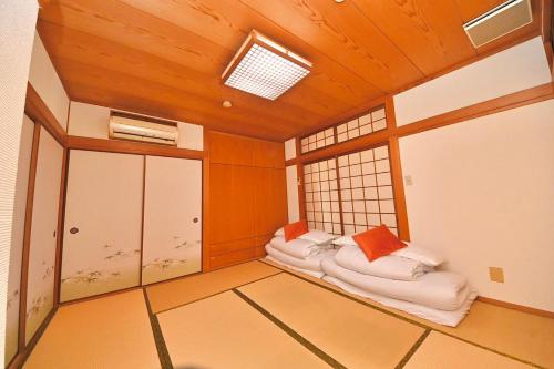 a room with three beds in it with a window at LIJ Stay Morinomiya 5BedRooms in Osaka