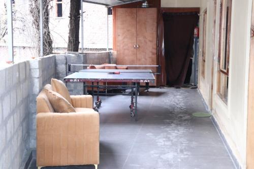 a room with a ping pong table and two couches at Blest Inn Kasol in Kasol