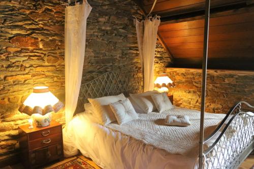 a bedroom with a bed in a stone wall at Cottage du Manoir de Trégaray in Sixt-sur-Aff