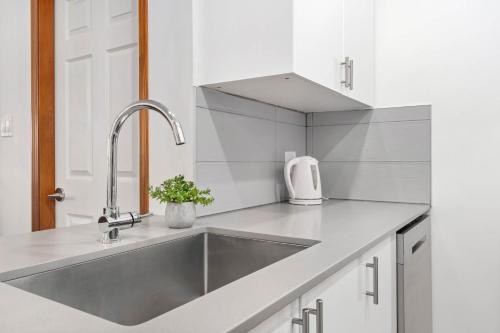 a kitchen with a stainless steel sink and white cabinets at 2BR in The Aspens, Ski In, Ski Out, Pool and Hot Tub, Gas Fireplace, Ski Valet, Gym in Whistler