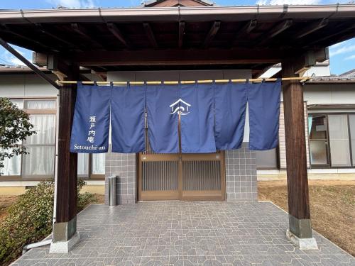 a blue banner is hanging in front of a garage at 瀬戸内庵Setouchian in Takamatsu