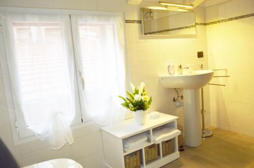 a bathroom with a sink and a toilet and a mirror at Il Cuore del Borgo - Holiday Home in Borgomaro