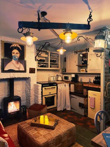 a kitchen with a fireplace and a table in a room at Rose Cottage in Whitby