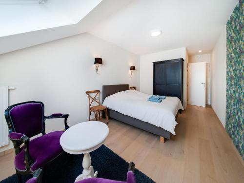 ein Schlafzimmer mit einem Bett, einem Tisch und Stühlen in der Unterkunft Charming Rural Retreat in Bourseigne-Neuve