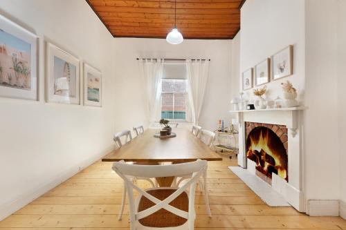 a dining room with a table and a fireplace at The Railway Parkview in Quarry Hill