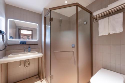 a bathroom with a shower and a sink at Hanting Hotel Nanjing Hexi Wanda in Nanjing