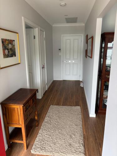 Bundanoon Rochester Guest House في بوندانون: غرفه فاضيه مع طاوله وباب