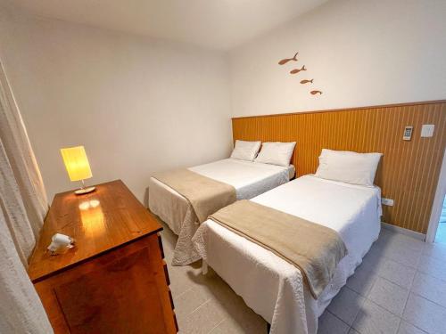 En eller flere senge i et værelse på Apê na Enseada - Ar, Wi-Fi, garagem e praia a pé!