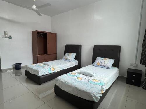 een slaapkamer met 2 bedden en een kast erin bij Homestay 76 in Mersing