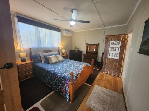 Jack's Shack Kingscote في كنغزكوت: غرفة نوم بها سرير ومروحة سقف