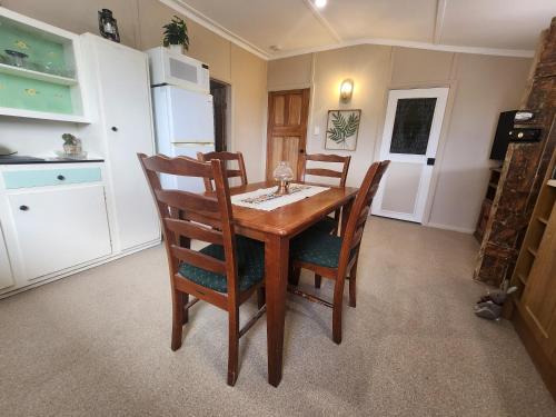 a kitchen with a wooden table and chairs at Jack's Shack Kingscote in Kingscote