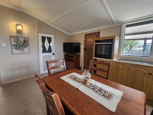 a dining room with a wooden table with chairs at Jack's Shack Kingscote in Kingscote