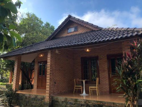a small brick house with a table and chairs at Nam Cat Tien Retreat in Tân Phú